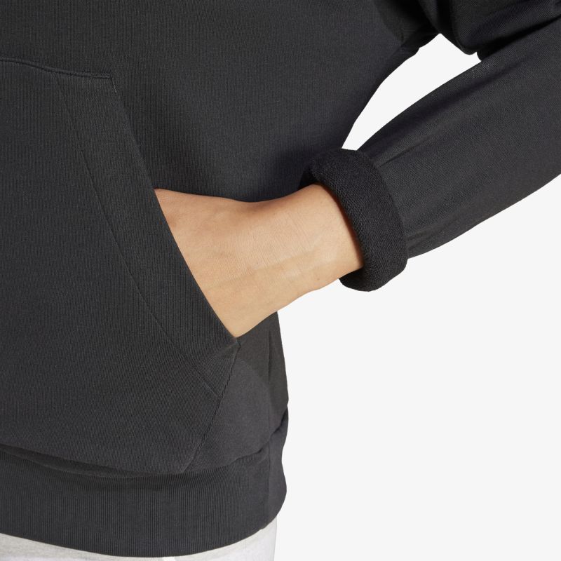 Detailaufnahme eines schwarzen Kapuzenpullovers mit Kängurutasche und geripptem Ärmelbündchen