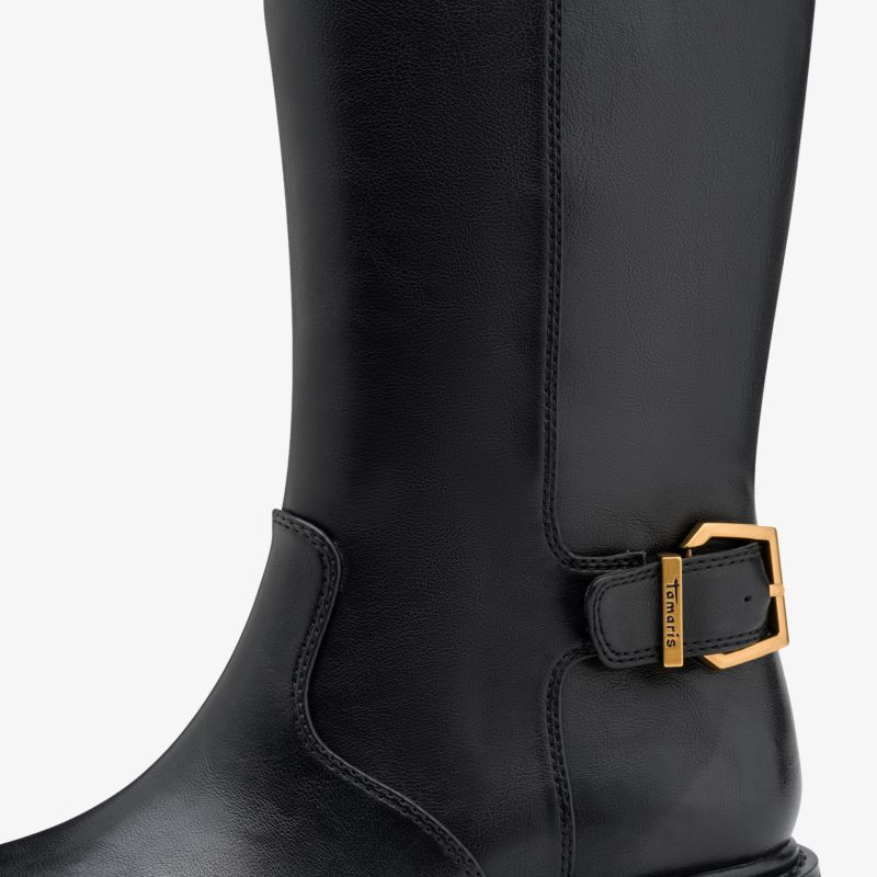 Eleganter schwarzer Lederstiefel mit goldfarbener Metallschnalle nahe dem Knöchel