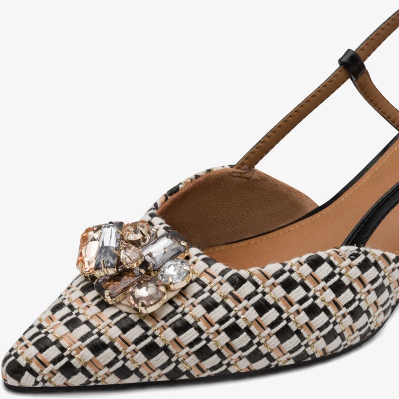 Spitzer Schuh mit elegantem Muster und auffälliger Schmuckverzierung vorne nah