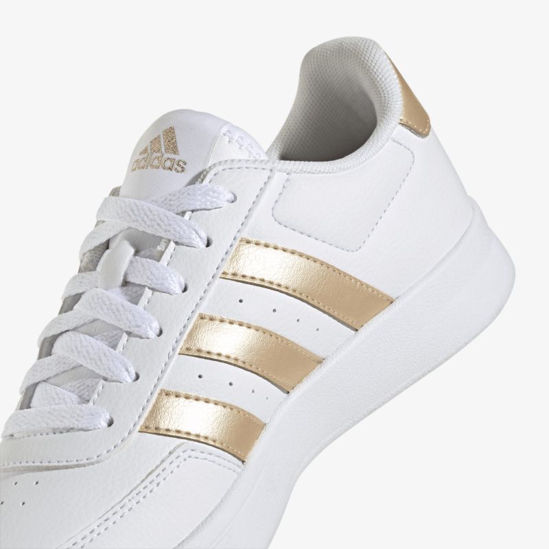 Weißer Sneaker mit goldenen Streifen, sportlich-elegant und modisch für vielseitige Looks.