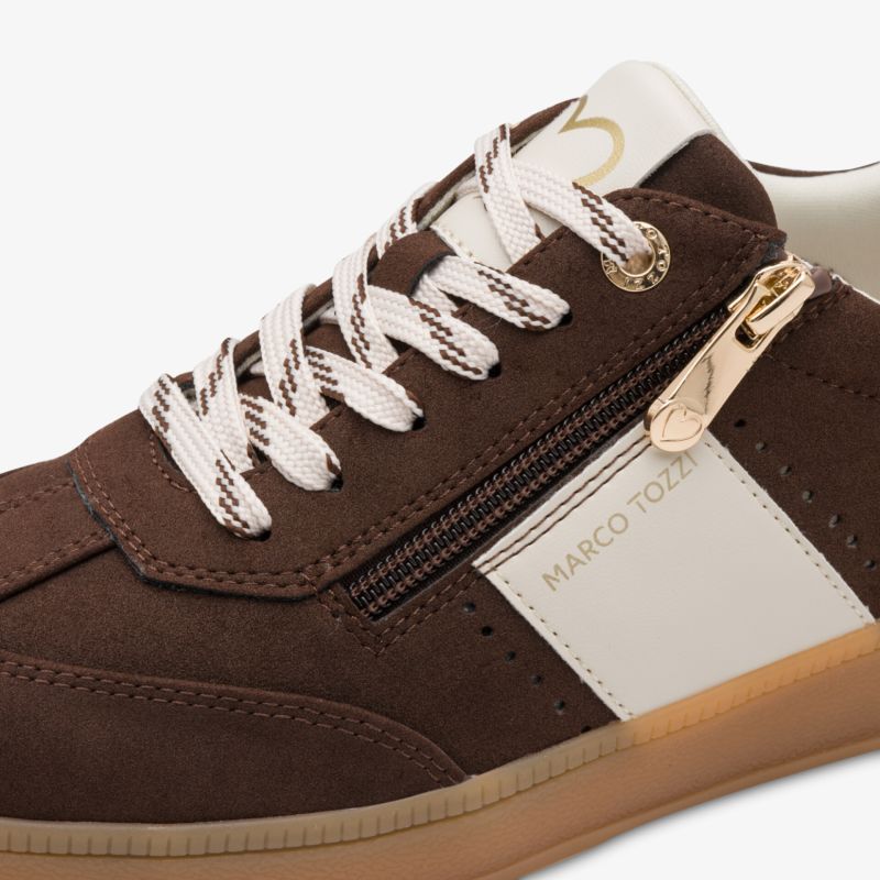 Seitliche Ansicht eines braunen Sneakers mit weißem Einsatz und seitlichem Reißverschluss für leichten Einstieg