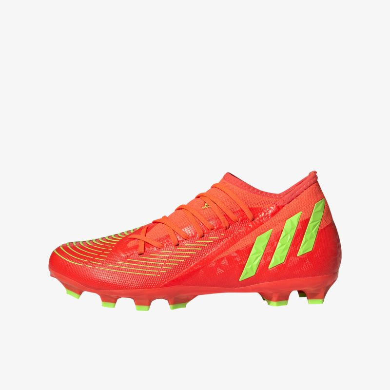 Roter Fußballschuh mit grünen Streifen und Stollen für optimalen Halt und dynamische Bewegungen.