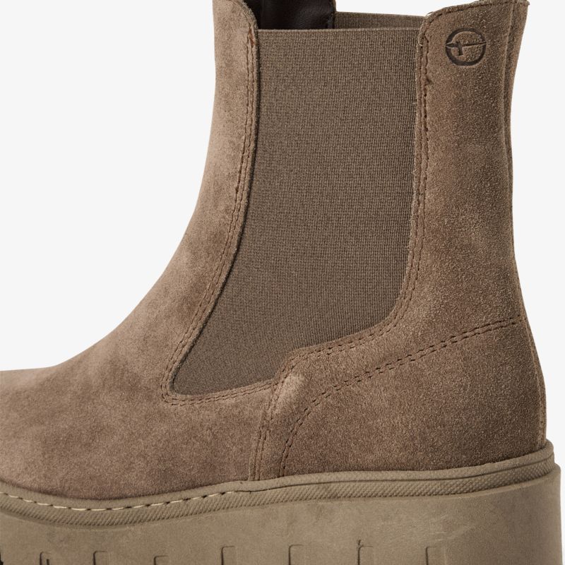 Detailaufnahme einer braunen Stiefelette mit elastischem Einsatz und robuster Plateau-Sohle aus Wildleder