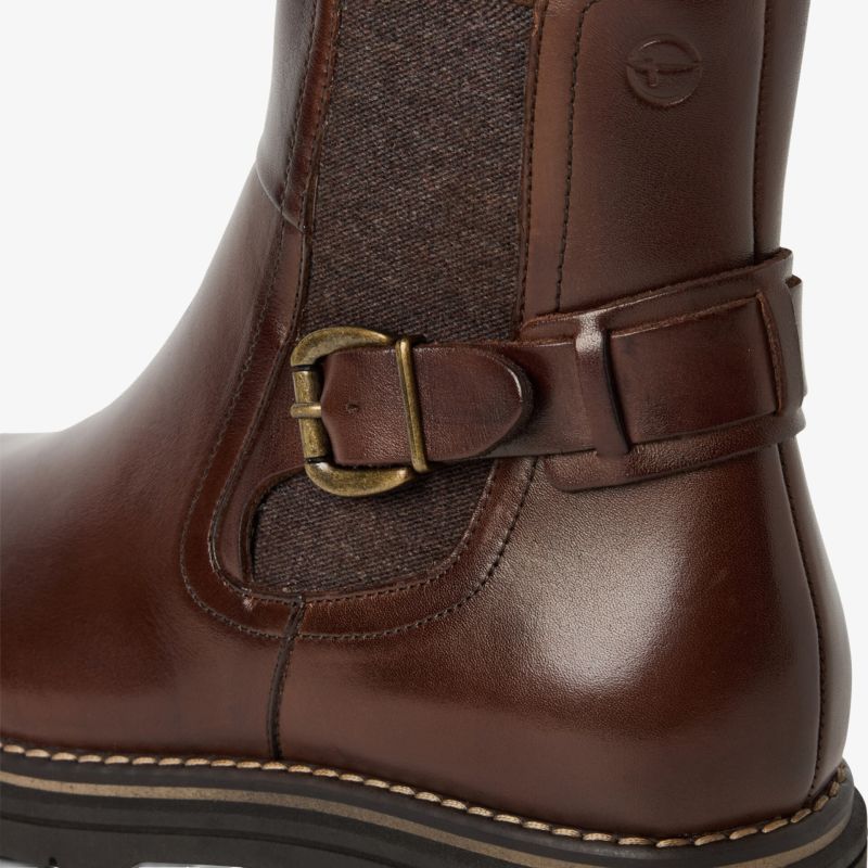 Brauner Lederstiefel mit dekorativem Schnallenverschluss und stabiler, feiner Naht an der Seite in Nahaufnahme