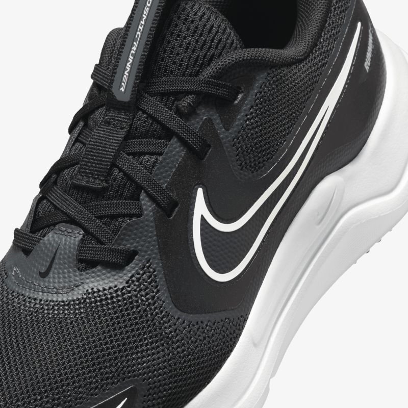 Detailaufnahme eines schwarzen Sportschuhs mit atmungsaktiver Mesh-Oberfläche, bequemer Schnürung und weißem Nike-Logo